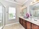 Bright bathroom features a double vanity, neutral paint, and a window for natural light at 2369 Baxter Se Pl, Concord, NC 28025