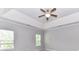 A spacious bedroom featuring a trey ceiling, ceiling fan and large windows for natural light at 2369 Baxter Se Pl, Concord, NC 28025