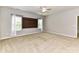 Large bedroom with neutral-colored walls and carpet features two windows and a ceiling fan at 2369 Baxter Se Pl, Concord, NC 28025