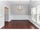 Classic dining room featuring wainscoting, chandelier, hardwood floors, and a large window at 2369 Baxter Se Pl, Concord, NC 28025