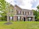 Charming brick two-story home with black shutters, manicured lawn, and American flag displayed by front door at 2369 Baxter Se Pl, Concord, NC 28025