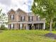 Charming brick two-story home with black shutters, manicured lawn, and American flag displayed by front door at 2369 Baxter Se Pl, Concord, NC 28025