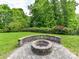 An inviting backyard area complete with a built-in fire pit and lush greenery at 2369 Baxter Se Pl, Concord, NC 28025