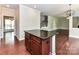 Kitchen island with granite countertop is viewed from the hardwood-floored living room at 2369 Baxter Se Pl, Concord, NC 28025