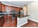 Kitchen featuring dark cabinets, granite countertops, stainless steel appliances, and a kitchen island at 2369 Baxter Se Pl, Concord, NC 28025