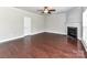 Cozy living room featuring hardwood floors, a fireplace, and a ceiling fan at 2369 Baxter Se Pl, Concord, NC 28025