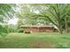 Backyard view of home from the lawn with trees providing shade and privacy at 2412 Wedgewood Dr, Salisbury, NC 28146