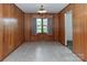 Dining room with wood-paneled walls, tile flooring, and a classic light fixture at 2412 Wedgewood Dr, Salisbury, NC 28146