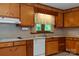 Functional kitchen featuring wood cabinets, white appliances, and a window above the sink at 2412 Wedgewood Dr, Salisbury, NC 28146