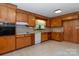 Classic kitchen with ample wood cabinetry, white appliances, and durable tile flooring at 2412 Wedgewood Dr, Salisbury, NC 28146