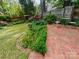 Inviting backyard with a brick patio, colorful garden, and well-manicured lawn at 3020 Hampton Ave, Charlotte, NC 28207