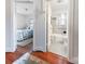 Hallway view into a bathroom with black and white tile and bedroom with floral bedding at 3020 Hampton Ave, Charlotte, NC 28207