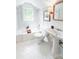 Bright bathroom featuring a classic white tub, a pedestal sink, and tiled flooring at 3020 Hampton Ave, Charlotte, NC 28207