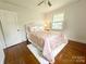 Comfortable bedroom featuring hardwood floors, a plush rug, and soft pink floral bedding at 3020 Hampton Ave, Charlotte, NC 28207