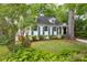 Charming home with green shutters, landscaped yard, and mature trees offering shade at 3020 Hampton Ave, Charlotte, NC 28207
