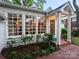 Well-maintained home with a brick patio, large windows, and landscaped garden beds at 3020 Hampton Ave, Charlotte, NC 28207