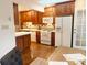 Kitchen featuring wood cabinets, white appliances, tile backsplash, and hardwood floors for a traditional look at 3020 Hampton Ave, Charlotte, NC 28207