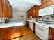 Spacious kitchen featuring wood cabinets, white countertops and appliances, and hardwood flooring at 3020 Hampton Ave, Charlotte, NC 28207