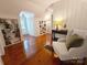 Sunlit living area with polished hardwood floors, built-in shelving, and a comfortable white armchair at 3020 Hampton Ave, Charlotte, NC 28207