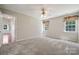 Inviting bedroom with neutral carpet, ceiling fan, and dual windows with curtains at 3038 Twin Peaks Ct, Monroe, NC 28110