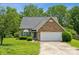 Charming brick and siding home with a two-car garage and well-manicured front lawn at 3038 Twin Peaks Ct, Monroe, NC 28110