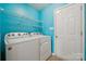 Bright laundry room with washer, dryer, and shelving for convenient storage at 3038 Twin Peaks Ct, Monroe, NC 28110