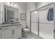 Clean bathroom featuring a glass-enclosed shower, granite countertop, and white cabinets at 329 Brambling Ct, Monroe, NC 28110