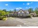 New construction featuring a modern exterior, stone accents, and a welcoming covered porch, set against a backdrop of lush greenery at 329 Brambling Ct, Monroe, NC 28110