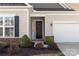 Inviting front entrance featuring a dark-colored door, manicured landscaping, and an attached two-car garage at 329 Brambling Ct, Monroe, NC 28110