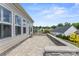Spacious back patio area with stylish pavers, a low stone wall, and ample seating at 329 Brambling Ct, Wesley Chapel, NC 28110