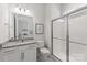 Modern bathroom with granite counters, tiled shower, and views to the attached bedroom at 329 Brambling Ct, Wesley Chapel, NC 28110