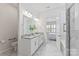 Bright bathroom featuring a double vanity, granite countertops, and a tiled shower at 329 Brambling Ct, Wesley Chapel, NC 28110