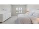 Bedroom with dresser, bed, and a window with plantation shutters for natural light at 329 Brambling Ct, Wesley Chapel, NC 28110
