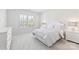 Bright bedroom with a white bedspread, side tables, and a window with plantation shutters at 329 Brambling Ct, Wesley Chapel, NC 28110