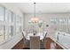 Dining area featuring plantation shutters, a modern light fixture, and access to the outdoor living space, creating a bright ambiance at 329 Brambling Ct, Wesley Chapel, NC 28110