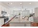 Open concept kitchen with a granite countertop island, stainless steel appliances, and a seamless view into the living space at 329 Brambling Ct, Wesley Chapel, NC 28110