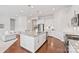 Bright kitchen boasts stainless appliances, granite countertops, an island with seating, and hardwood floors throughout the space at 329 Brambling Ct, Wesley Chapel, NC 28110