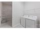 Bright laundry room includes a washer and dryer as well as closet with wire shelving at 329 Brambling Ct, Wesley Chapel, NC 28110