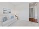 Cozy living room with a white sofa, blue pillows, and bright natural light from the hallway at 329 Brambling Ct, Wesley Chapel, NC 28110