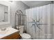 Bathroom featuring a single sink vanity, toilet with shelving, and shower with compass shower curtain at 351 Fletcher Rd, Union Grove, NC 28689