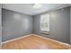 This bedroom has grey walls, vinyl wood floors, a window with blinds, and white baseboard trim at 351 Fletcher Rd, Union Grove, NC 28689