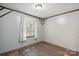 This bedroom has grey walls, wood floors, a window with blinds, and trim with brown decorative accents at 351 Fletcher Rd, Union Grove, NC 28689