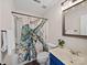 Bathroom features a tub with an octopus shower curtain, vanity with blue cabinet and decorative mirror at 404 Basingdon Ct, Waxhaw, NC 28173