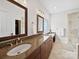 Elegant bathroom featuring granite countertops, dual sinks, and decorative mirrors at 404 Basingdon Ct, Waxhaw, NC 28173