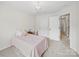 Bright bedroom with neutral tones, featuring a teddy bear on the bed, and white doors at 404 Basingdon Ct, Waxhaw, NC 28173