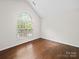 Well-lit bedroom featuring hardwood floors and a large window, creating a bright and airy space at 404 Basingdon Ct, Waxhaw, NC 28173