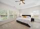 Bright bedroom boasts tray ceiling, neutral carpet, and an abundance of natural light through large windows at 404 Basingdon Ct, Waxhaw, NC 28173