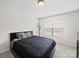 Bedroom with a dark bed frame, a window with blinds, light-colored carpet, and modern lighting at 404 Basingdon Ct, Waxhaw, NC 28173