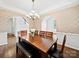 Elegant dining room featuring hardwood floors, decorative wallpaper, and a modern chandelier at 404 Basingdon Ct, Waxhaw, NC 28173