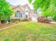 Expansive front yard with lush green grass and colorful landscaping surrounding this beautiful home at 404 Basingdon Ct, Waxhaw, NC 28173